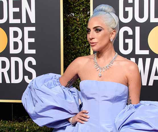 Atriz e cantora Lady Gaga veste vestido azul com um toque de lavanda, by Valentino, no Golden Globe 2019